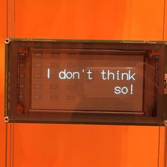 a sign that says i don't think so in front of an orange wall