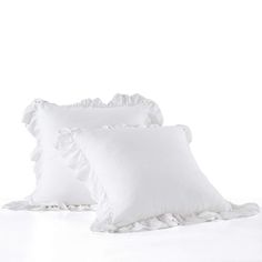 three white pillows with ruffled edges on top of each other, in front of a white background