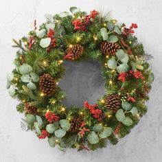 a christmas wreath with pine cones and red berries