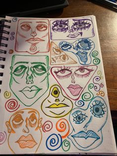 an open notebook with drawings of faces and spirals on the cover, sitting on a table