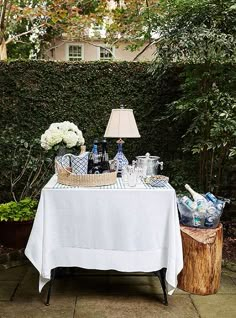 a table with bottles and vases on it in front of a fenced area