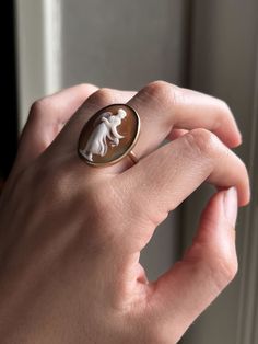 A stunning, bezel set cameo conversion ring featuring a side-facing figure among the gossamer billows of a greco-roman gown. English. This lovely conversion is set in 9k gold, circa 1890. Materials & Features: 9k Gold Age/Origin: English, 1890 Measurements: 1.25” north-south, 4.38g, Size 7.75 Condition: Excellent condition. Minor associated age wear. Please view and inspect any photos closely. We endeavor to fully disclose all condition information clearly and concisely, however, please note tha Roman Gown, Greco Roman, Cameo Earrings, Historical Jewellery, Cameo Jewelry, Cameo Ring, Cameo Necklace, North South, Bezel Setting