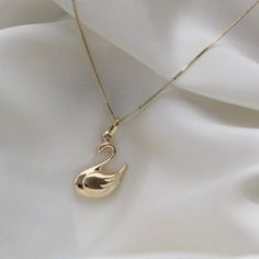 "14K Solid Gold Swan Necklace . . . * Pendants Measurements With Bail: (30 x 15 mm) * Chain is included ( 1MM Box Chain) * Stamp: Real 14k Gold * Never gold filled or plated * Hypoallergenic * Water Resistant * Scratch Resistant * Packaged With Free Gift Box . . . If you have any questions, just hit the \"Message the Seller\" button ( bottom right of the page) and we will get back to you within a few hours. . . . Mailed in a cute white package great for gifting. . . . Check our Social Media @Tal Swan Jewelry, Swan Pendant, Desk Room, Gold Swan, Swan Necklace, Necklace Pendants, Bird Necklace, Jewelry Essentials, Bird Jewelry