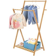 a wooden clothes rack with two shirts hanging from it's sides, and a stuffed animal toy on the bottom shelf