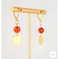 These beautiful carnelian gold disc drop earrings from Miel Jewelry Shop are a pretty addition to any outfit. The deep, vivid orange carnelian beads feature ribbons of peach and white and are paired with gold-plated circular drops. The earrings are finished with gold-plated sterling silver lever backs. They measure 1.75 inches in length. Natural variations in the stones mean your purchased item may not be exactly as the one pictured. Due to natural variations in the gemstones your purchased item Orange Gemstone Drop Earrings, Orange Natural Stones Drop Earrings, Orange Natural Stone Drop Earrings, Orange Gemstone Dangle Earrings, Elegant Orange Earrings With Natural Stones, Orange Gemstone Dangle Jewelry, Gold Carnelian Earrings With Ear Wire, Carnelian Drop Earrings With Natural Stones, Carnelian Gold Earrings With Ear Wire