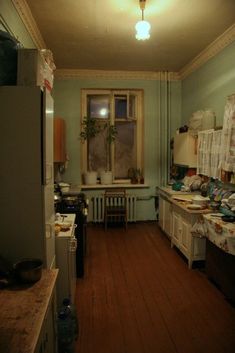 a kitchen with wooden floors and green walls