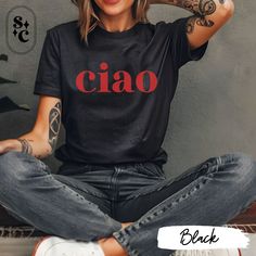 Elevate your style with our trendy "Ciao" shirt, featuring the word "Ciao" in bold red font. Perfect for the downtown girl, this cool minimalist tee exudes effortless chic and Italian flair. This cute preppy t-shirt is ideal for anyone embracing a relaxed yet fashionable look. Whether you're strolling through the city or enjoying a coffee date, this trendy shirt is versatile and stylish. Looking for an Italia-themed gift? This "Ciao" shirt captures the essence of Italian vibes, making it a thoughtful and fashionable present. Add a touch of European elegance to your wardrobe with this must-have Ciao shirt and make every outfit a statement! 💕Proudly printed on Bella Canvas Unisex T-shirt 3001 - 100% Airlume combed and ringspun cotton - Light fabric - Super soft - Runs true to size 💕Size Th Chic Cotton T-shirt With Graphic Print, Chic Summer T-shirt With Letter Print, Trendy Short Sleeve Shirt With Letter Print, Trendy Black Shirt With Letter Print, Chic Relaxed Fit T-shirt With Crew Neck, Chic Relaxed Fit Crew Neck T-shirt, Trendy Summer Tops With Name Print, Casual Summer Tops With Name Print, Trendy Short Sleeve T-shirt With Name Print