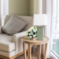 a small table with flowers on it next to a couch