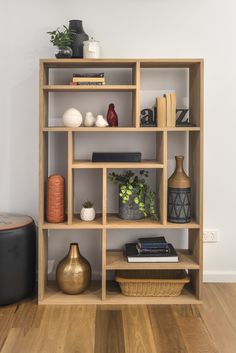 a wooden shelf with books, vases and other decorative items on top of it