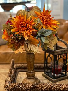 a vase filled with flowers sitting on top of a wooden table next to a lamp