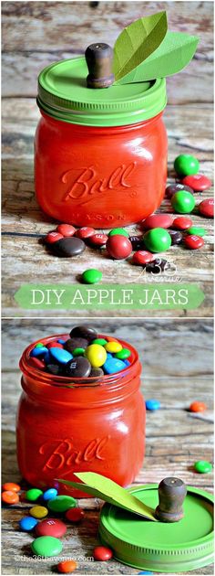 an orange mason jar filled with candy and some green leaves on top of the jars