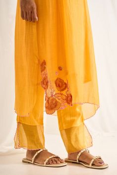 Yellow three fourth sleeves cutwork edged kurta with gardenia patchwork on the sleeves, hem and pintux detail on one side yoke. Paired with a stitchline embroidered sheer hem pant and an inner. - Aza Fashions Chanderi Palazzo Set With Cutdana For Spring, Spring Chanderi Palazzo Set With Cutdana, Chanderi Kurta With Cutdana For Spring, Spring Embroidered Cotton Silk Salwar Kameez, Spring Cotton Silk Dupatta With Embroidered Border, Designer Palazzo Set With Embroidered Border For Spring, Yellow Cotton Silk Kurta For Spring, Summer Chanderi Palazzo Set With Floral Embroidery, Spring Designer Wear Palazzo Set With Embroidered Border