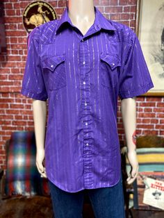 "Vintage men's western cowboy rodeo ranch purple shirt short sleeve size 2xl. Two chest pockets, pearl snap on buttons. Good used condition, tag label Ely Cattleman. Please, check carefully the measurements, photos and description of the article before buying it, we do not accept changes or returns. Measuraments lying face down from outside: 28\" Across chest underarm to underarm. 21 1/2\" Shoulder seam to seam. 11 Sleeve length from shoulder seam to hem. 32\" Long, collar to hem down. Let me kn Western Short Sleeve Shirt With Button Closure, Western Short Sleeve Tops With Button Closure, Purple Short Sleeve Tops With Pockets, Fitted Short Sleeve Shirt For Rodeo, Western Style Short Sleeve Shirt For Rodeo, Vintage Short Sleeve Purple Shirt, Vintage Purple Short Sleeve Shirt, Vintage Short Sleeve Shirt For Rodeo, Summer Rodeo Shirt With Pockets