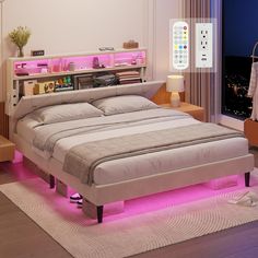 a bed that is sitting in the middle of a room with pink lights on it