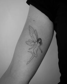 a woman's arm with a small tattoo of a fairy on the back of her leg