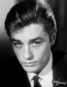 a black and white photo of a young man in a suit with a tie on