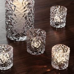 several clear glass candles sitting on top of a wooden table