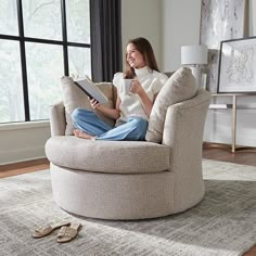 a woman sitting in a chair reading a book