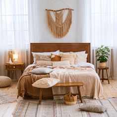 a bedroom with white walls and wooden furniture, including a bed covered in beige linens