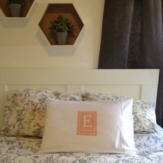 a bed with two potted plants on the wall above it and an e pillow