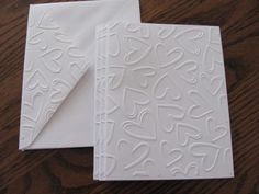 two pieces of paper with white designs on them