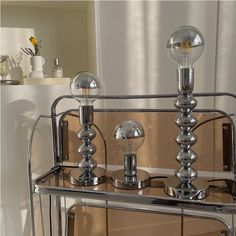 a mirrored table with two lamps on it