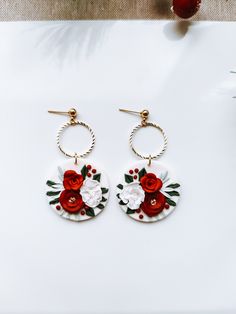 the earrings are decorated with red and white flowers