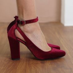 a woman wearing red high heels on top of a wooden floor