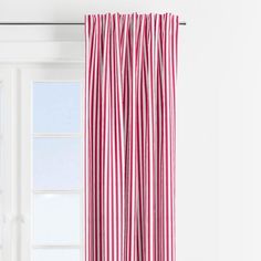 a red and white striped curtain hanging in front of a window