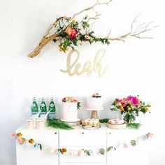 a table topped with cake and flowers next to a wall