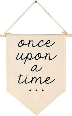 a sign that says once upon a time hanging from a rope on a white wall