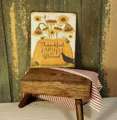 a small wooden bench with a sign on it that says, thanksgiving grateful for the season