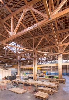 the inside of a building with wooden benches and tables in it's center area