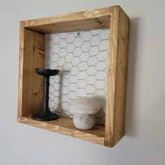 a wooden shelf with two different items on it and a tile wall in the background