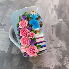 a coffee cup decorated with pink roses and other things on the inside, sitting on a table