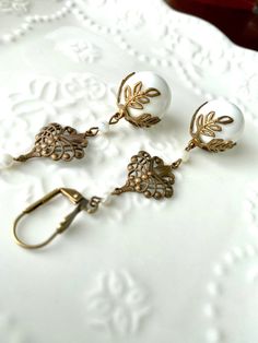 White Large Filigree and Leaf Brass Drop Dangle Long Earrings Large white glass beads with a vintage leaf cap and vintage filigree finding dangle from antiqued brass lever back ear wires. They may be changed to French hook ear wires or post style earrings. See last picture for reference. You will be prompted to select your preference when you add them to your cart. They measure 2 7/8 inches from top of lever back style wire. 👑 More Dangle Earrings: https://www.etsy.com/shop/tinygoldcrowns?ref=s Vintage Dangle Earrings, Manga Jewelry, Earrings Large, Long Dangle Earrings, Large Earrings, Style Earrings, Jewelry Diy, Large White, Long Earrings