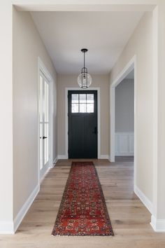 an empty hallway with a rug on the floor