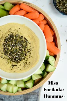 a bowl filled with hummus, carrots and celery next to other vegetables