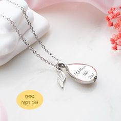 a silver necklace with an angel wing on it and the words, ships next day