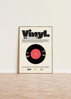 a vinyl record sitting on top of a hard wood floor next to a white wall