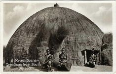 an old black and white photo of some people in front of a hut