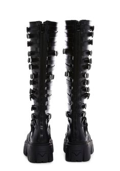 in a vegan leather construction. These knee high boots have decorative buckles on both sides, treaded soles, and back zipper closures. Gothic Leather Knee-high Boots, Edgy Knee-high Boots With Buckle Closure, Gothic Leather Knee-high Boots For Alternative Fashion, Edgy Knee-high Boots With Zipper Closure, Edgy Knee-high Moto Boots With Buckle, Edgy Knee-high Moto Boots With Buckle Closure, Black Punk Knee-high Boots With Buckle, Black Punk Knee-high Boots With Buckle Closure, Black Punk Style Knee-high Boots With Buckle