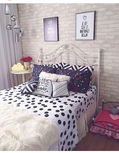 a bedroom with white brick walls and black and white bedding