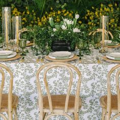 the table is set with white flowers and greenery