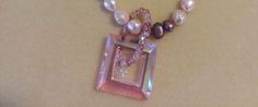 a necklace with pearls and a pink pendant