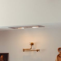 a bathroom with a sink, toilet paper dispenser and pictures on the wall