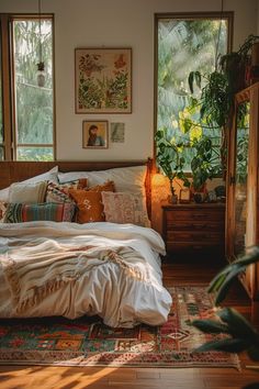 a bed sitting in a bedroom next to two windows with potted plants on them