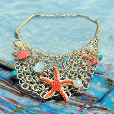 This is a perfect vintage gold starfish  Beach necklace. It has many little  Charms and a large coral cabochon  Starfish as the main attraction. This is In good preloved condition. This would  Be a great gift idea or wonderful for A summer vacation trip. This is Amazing! Gold Shell Necklace With Starfish Charm For Summer, Gold Starfish Charm Necklace For Beach Season, Gold Necklace With Starfish Charm For Beach Season, Star-shaped Necklaces For Beach Summer, Bohemian Starfish Necklaces With Lobster Clasp, Gold Starfish Necklaces For Vacation, Starfish Shell Necklace For Vacation, Starfish Necklace For Beach Season, Starfish Necklace With Lobster Clasp For Vacation