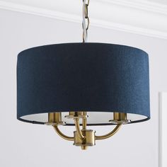 a chandelier with a blue shade hanging from it's side in a room