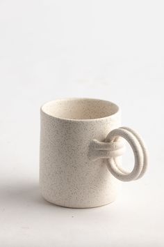 a white coffee cup with a knot on the handle